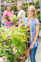 Smiling woman at garden center shopping plants