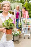 Senior woman hold potted flower garden shop