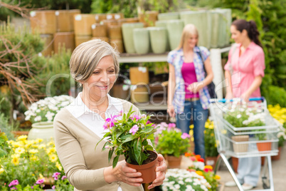 Garden centre senior lady hold potted flower