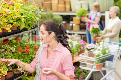 Woman choose potted flower in garden store