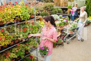 Woman buying potted flower in garden center