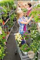 Woman shopping for flowers in garden centre