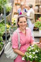 Garden centre woman hold white potted hibiscus