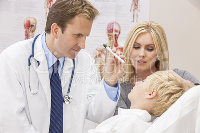 Male Doctor Examining Boy Child With Mother