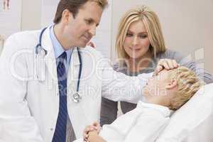 Male Doctor Examining Boy Child With Mother