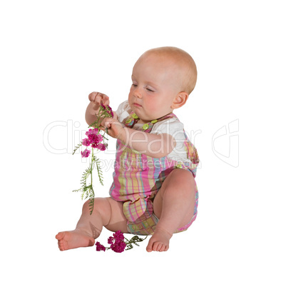 Pretty young baby playing with flowers