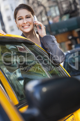 Young Woman Talking on Cell Phone By Yellow Taxi