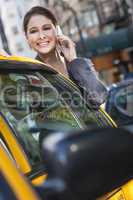 Young Woman Talking on Cell Phone By Yellow Taxi