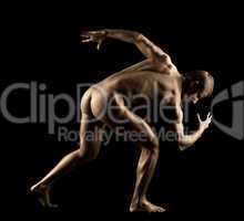 Athletic man posing nude in dark