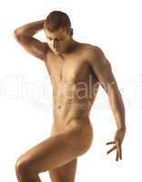 Strong athletic man posing nude with gold skin