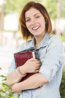 Smiling Young Female Student Outside with Books