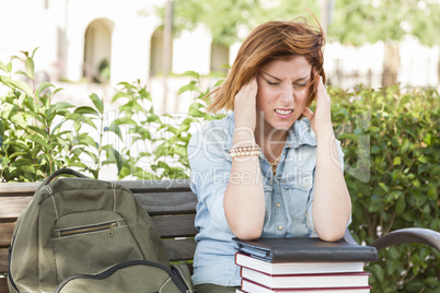Female Student Outside with Headache Sitting with Books and Back