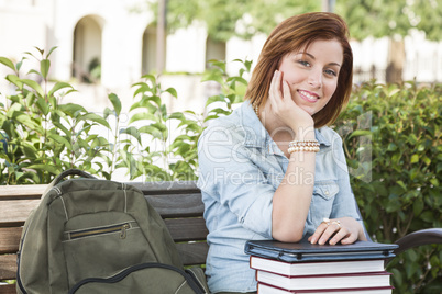 Young Female Student Sitting On Campus with Backpack and Books