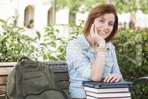 Young Female Student Sitting On Campus with Backpack and Books