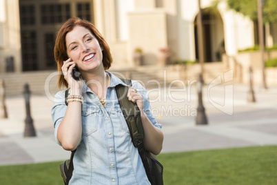 Young Female Student Walking Outside Using Cell Phone