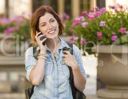 Young Female Student Walking Outside Using Cell Phone
