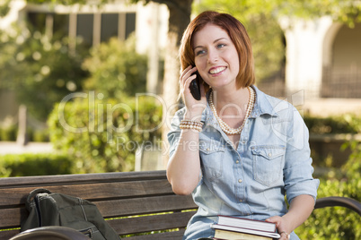 Young Female Student Outside Using Cell Phone Sitting on Bench