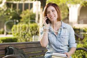 Young Female Student Outside Using Cell Phone Sitting on Bench