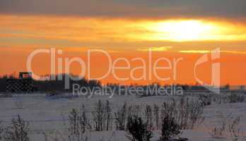 airfield in front of a winter sunset in snow