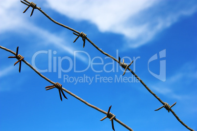 barbed wire against the blue sky