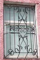 black metal forged carved lattice at a plastic white window