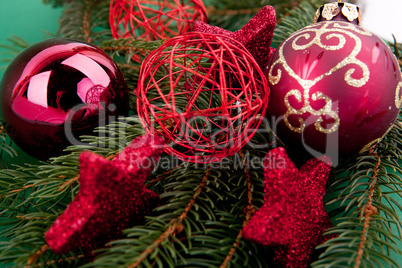 Festlicher Christbaumschmuck mit roten Weihnachtskugeln auf grü