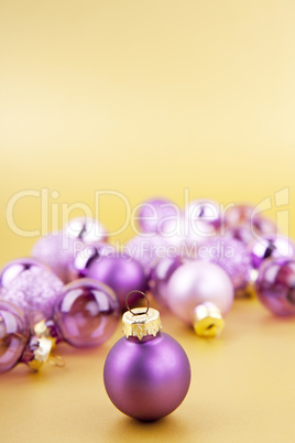 Lila Christbaumkugeln Weihnachtsschmuck auf goldenem Hintergrund