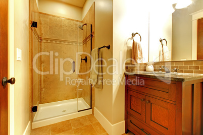 Bathroom with wood cabinet and tile shower.