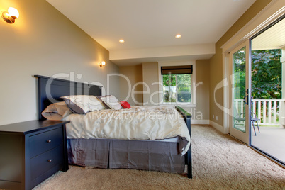 Bedroom with carpet and large balcony door.