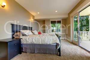 Bedroom with carpet and large balcony door.