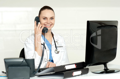 Beautiful nurse talking on phone with patient