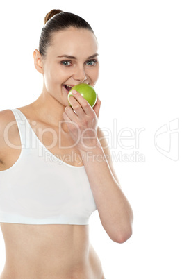 Pretty fit trendy woman eating fresh green apple