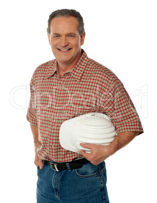 Smiling senior architect holding white safety hat