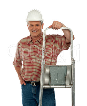 Smiling aged worker posing with ladder
