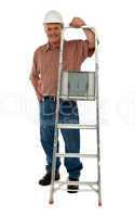 Smiling construction worker holding ladder