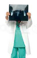 Male surgeon hiding his face with x-ray report