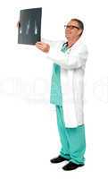 Full length portrait of senior surgeon holding x-ray