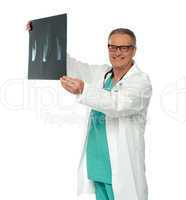 Smiling doctor in glasses reviewing x-ray report