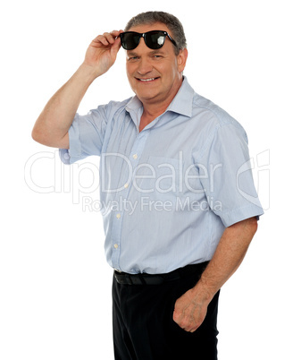 Casual man holding sunglasses over his head