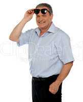Casual man holding sunglasses over his head