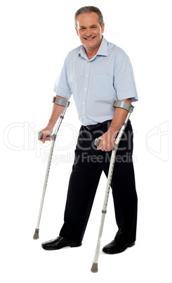 Senior man standing with the help of crutches