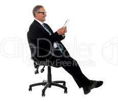 Well dressed corporate male holding wireless tablet