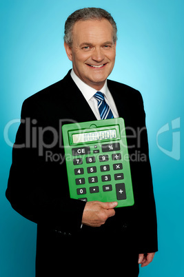 Senior executive posing with big green calculator