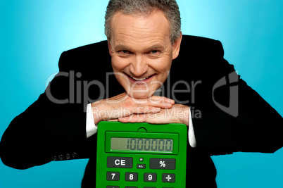 Aged corporate male resting face on big calculator