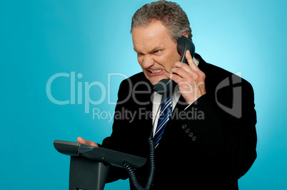 Irritated businessman communicating on phone