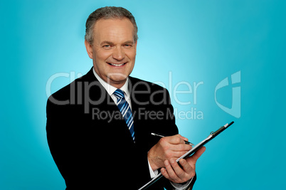 Attractive senior man writing on clipboard