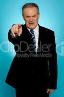Angry senior businessman pointing finger at you