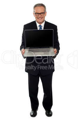Aged businessman showing newly launched laptop