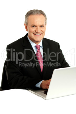 Confident businessman working on laptop