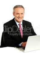 Confident businessman working on laptop